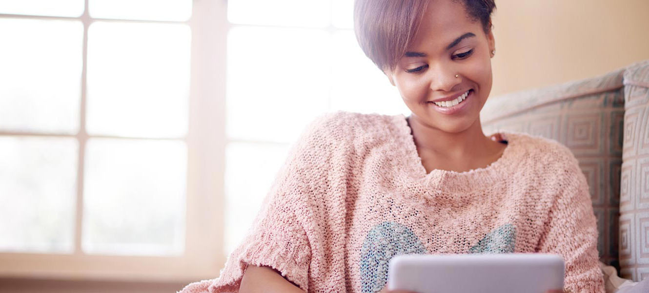 Young woman using tablet in living room.